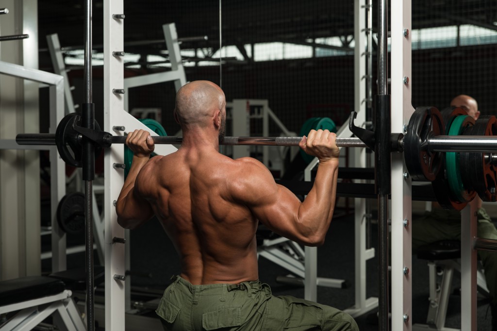 Mature Man Doing Shoulder Exercises In The Gym